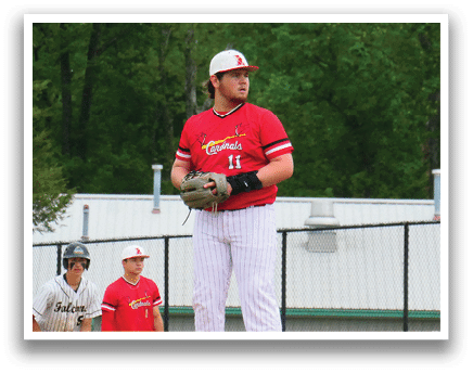 A baseball player in a red shirt and white pants is standing on a mound. Description generated by AI