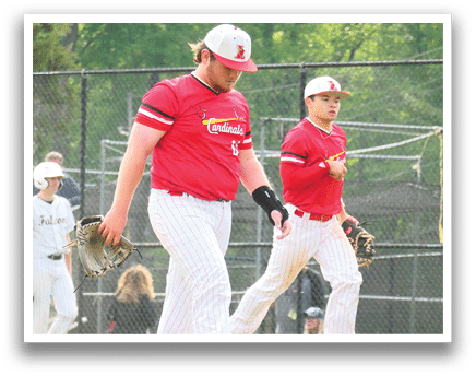 Two baseball players wearing red shirts and white pants. Description generated by AI