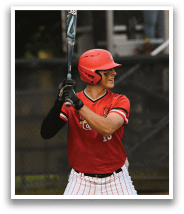 A baseball player in a red shirt and white pants holding a bat. Description generated by AI