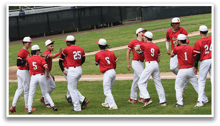 A group of people wearing red and white uniforms are standing on a baseball field. Description generated by AI