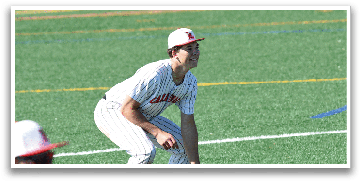 A baseball player in a white and red uniform is kneeling on the field. Description generated by AI
