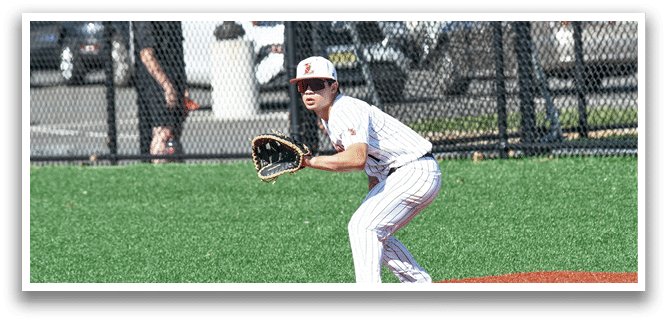 A baseball player in a white uniform is holding a catcher's mitt and standing on a baseball field. Description generated by AI