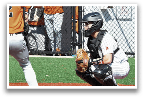A baseball player is holding a bat, ready to hit the ball. Description generated by AI