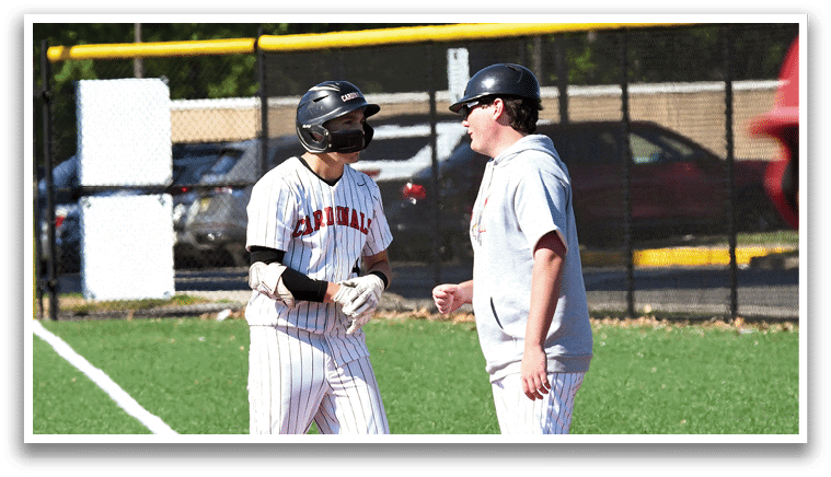 A baseball field with two men talking. Description generated by AI