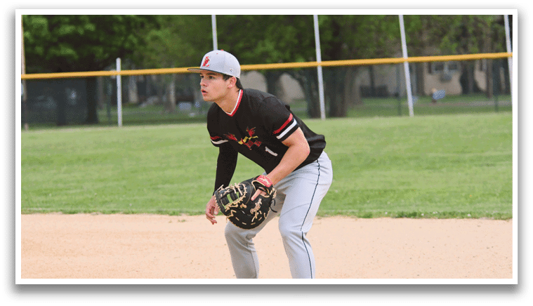 A baseball player wearing a black shirt and grey pants. Description generated by AI