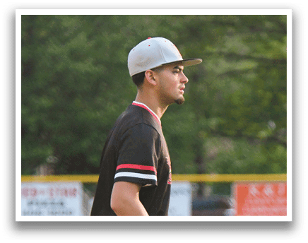 A baseball player wearing a black shirt and white pants. Description generated by AI