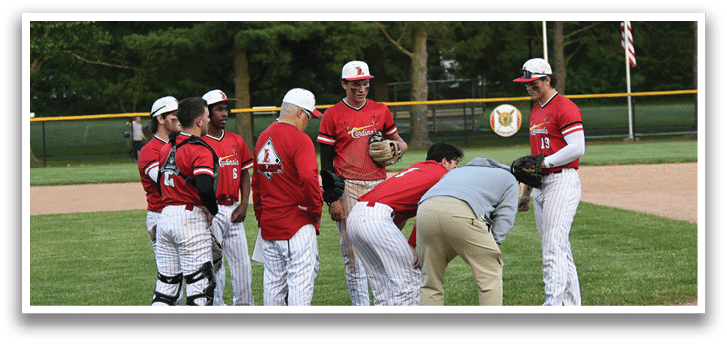 A group of people wearing red and white uniforms are standing on a baseball field. Description generated by AI