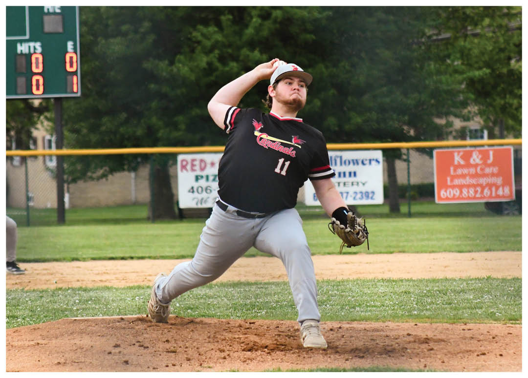 A baseball player in a black shirt and grey pants is pitching a ball. Description generated by AI