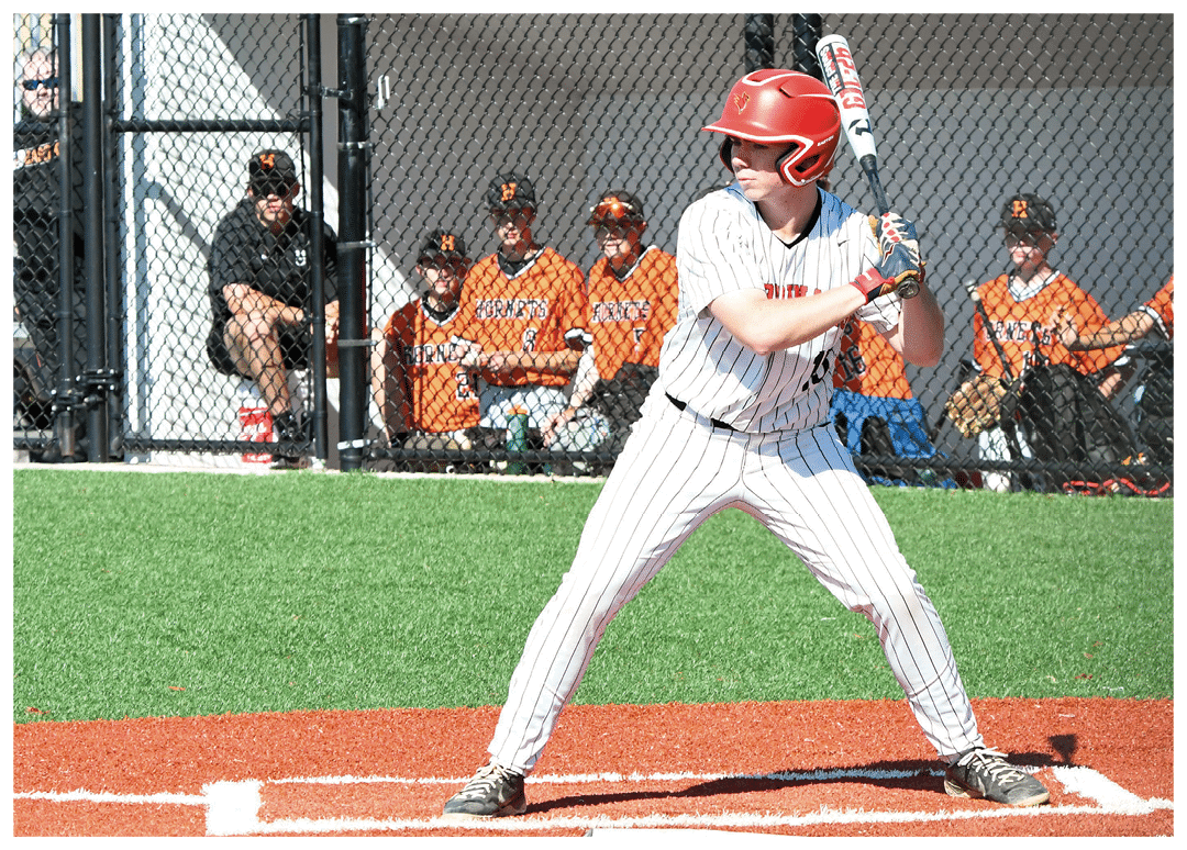 A baseball player in a red helmet and white uniform is holding a bat and getting ready to swing. Description generated by AI