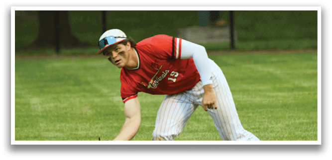 A baseball player in a red shirt and white pants with a black glove. Description generated by AI