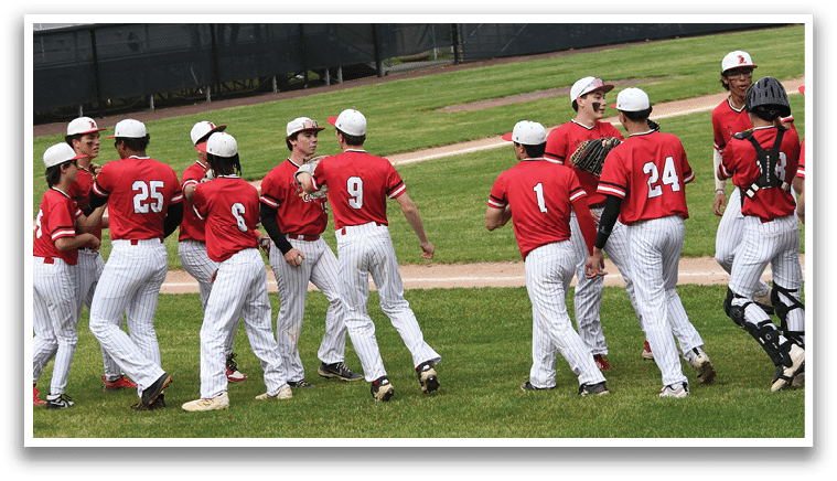 A group of people wearing red shirts and white pants are standing on a baseball field. Description generated by AI
