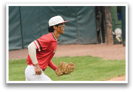 A baseball player wearing a red shirt and white hat. Description generated by AI