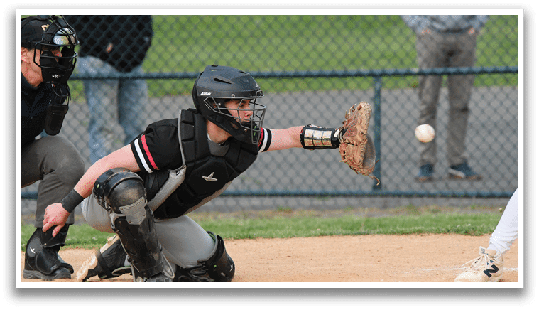 A baseball player catching a ball. Description generated by AI