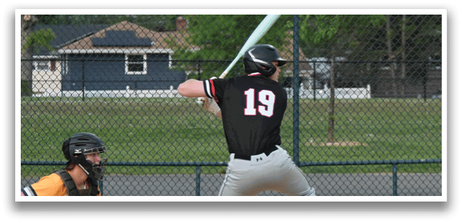 A baseball player in a black and white uniform is swinging a bat. Description generated by AI