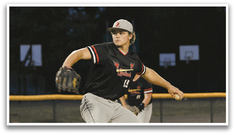 A baseball player in a black and red shirt is pitching a ball. Description generated by AI