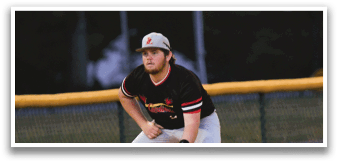 A baseball player in a black and red shirt is crouched down on the field. Description generated by AI