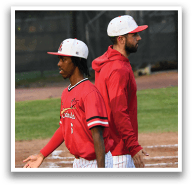 Two men wearing red and white baseball caps and jackets. Description generated by AI