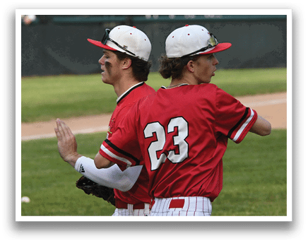 Two baseball players wearing red and white uniforms. Description generated by AI