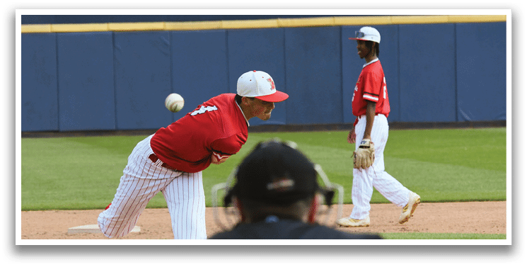 A baseball player in a red shirt and white pants is throwing a ball. Description generated by AI