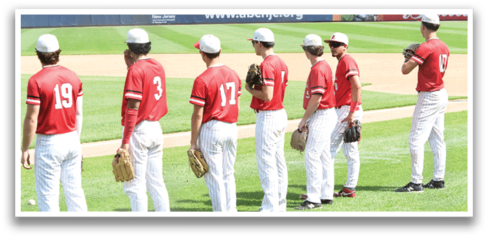 A group of baseball players standing on a field. Description generated by AI