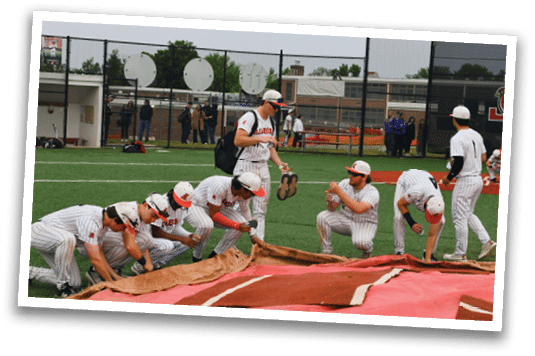 A group of baseball players kneeling on a field. Description generated by AI