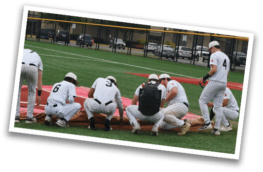 A group of baseball players wearing white uniforms. Description generated by AI