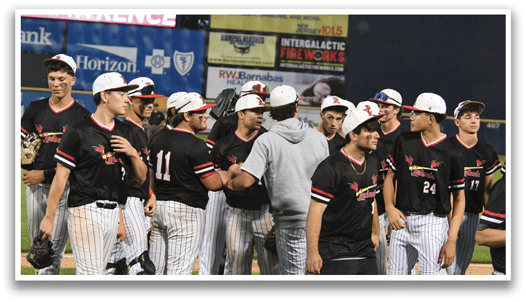 A group of baseball players wearing black and red uniforms. Description generated by AI