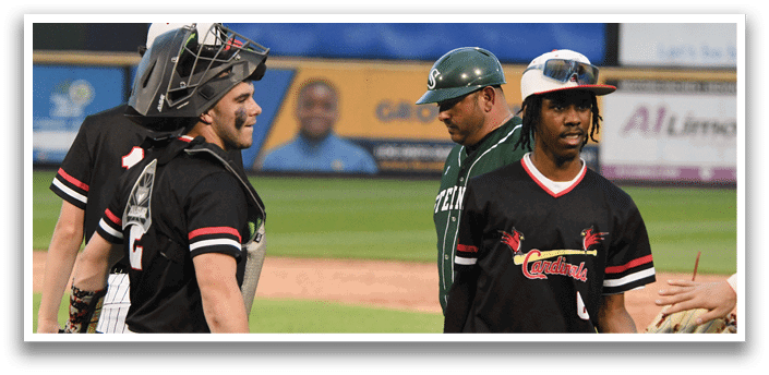 A baseball player wearing a black shirt and green hat. Description generated by AI
