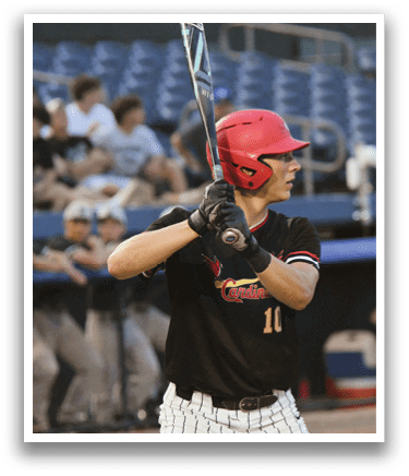 A baseball player wearing a red helmet and black shirt is holding a bat. Description generated by AI