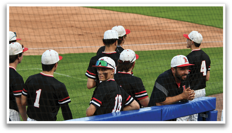 A group of baseball players wearing black shirts and red hats. Description generated by AI