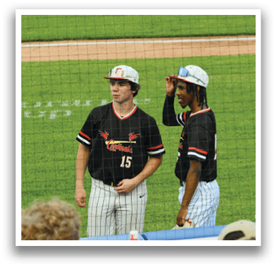 A group of baseball players wearing black and red uniforms. Description generated by AI