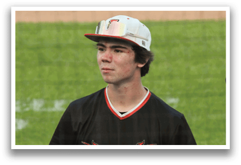 A baseball player wearing a black jersey with the word Cardinals on it. Description generated by AI
