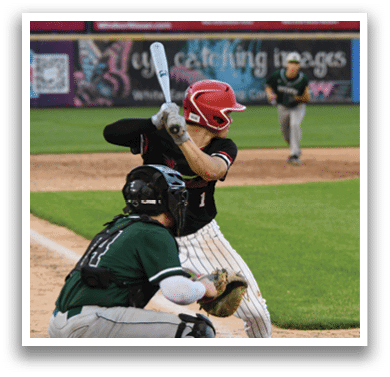 A baseball player in a green shirt and white pants is holding a bat and getting ready to swing. Description generated by AI