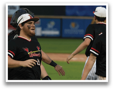 A baseball player wearing a black shirt with the number 14 on it. Description generated by AI