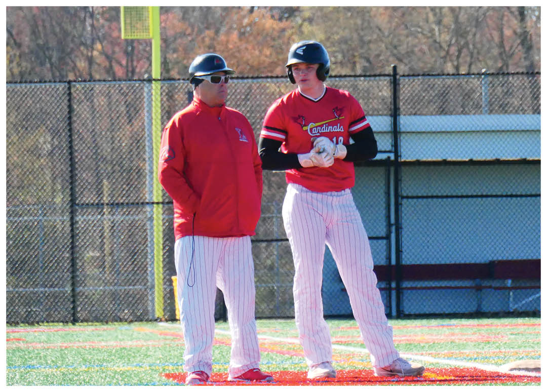 Two men standing on a baseball field. Description generated by AI