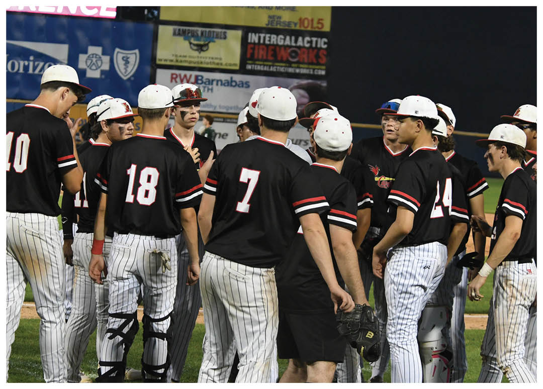A group of baseball players wearing black and white uniforms. Description generated by AI