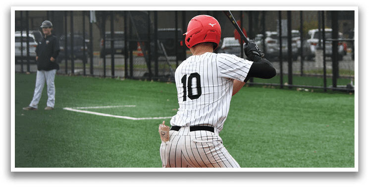 A baseball player in a red helmet and black and white uniform is swinging a bat. Description generated by AI