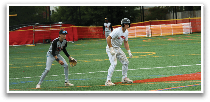 A baseball field with a man in a white uniform standing on the grass. Description generated by AI