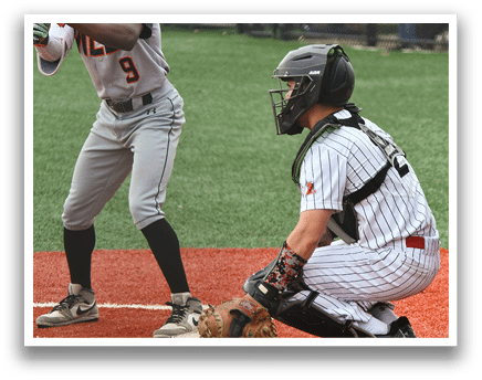 A baseball player is holding a bat, ready to swing. Description generated by AI