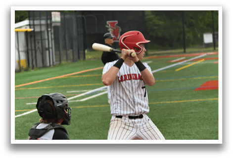 A baseball player is holding a bat and getting ready to hit a ball. Description generated by AI