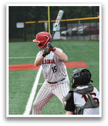 A baseball player is holding a bat and getting ready to hit a ball. Description generated by AI