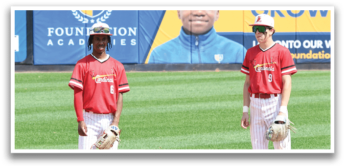 Two boys wearing red shirts and white pants. Description generated by AI