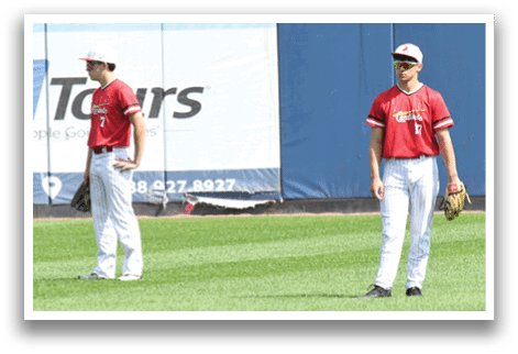 Two baseball players standing on a field. Description generated by AI