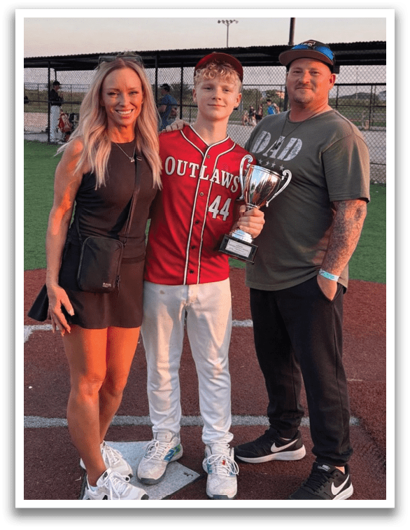 A man, woman, and boy are standing on a baseball field. The boy is holding a trophy. AI generated content