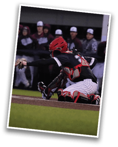 A baseball player wearing a red helmet is squatting down, ready to catch a ball. AI generated content