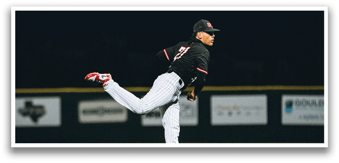 A baseball player in a black shirt and red shoes is pitching a ball. AI generated content