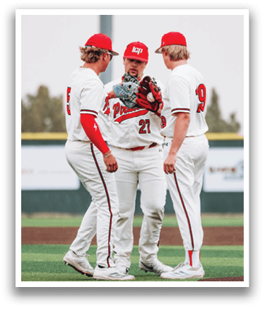 Three baseball players wearing white uniforms and red and white caps are standing on a field. They are talking to each other, possibly discussing their game strategy. AI generated content
