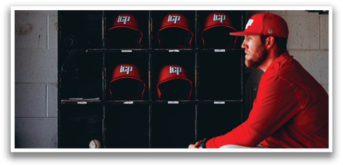 A man wearing a red baseball cap and a red shirt sits in a dugout. AI generated content