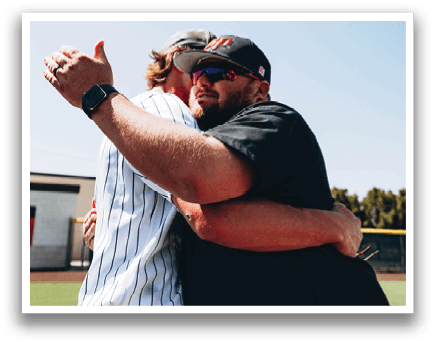 Two men hugging on a baseball field. AI generated content