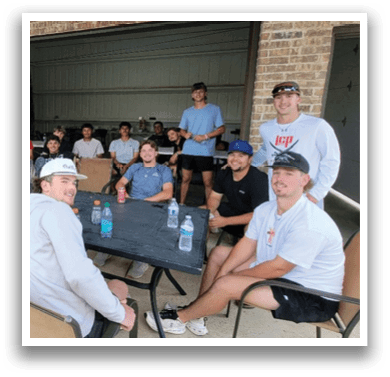 A group of people are sitting around a table in a garage. AI generated content